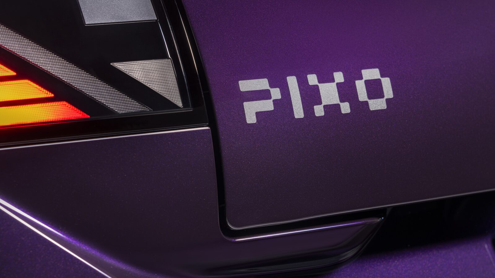 Close-up of the Nissan PIXO rear light cluster and PIXO badge on the purple bodywork.
